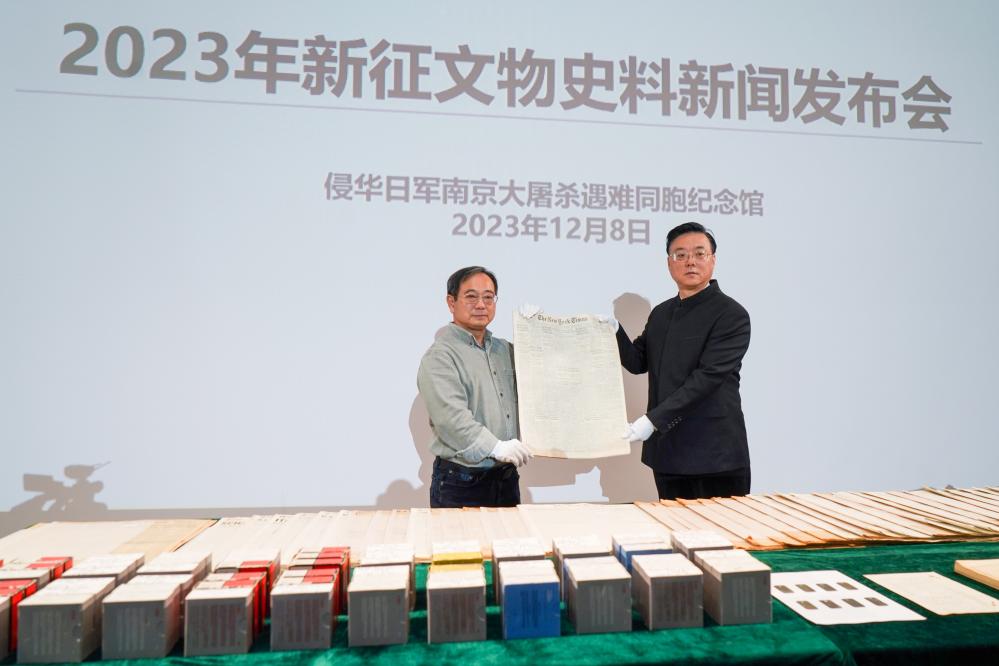 2023年12月8日,美籍华人鲁照宁(左)向侵华日军南京大屠杀遇难同胞纪念馆捐赠了125份美国报纸。 新华社记者李博 摄